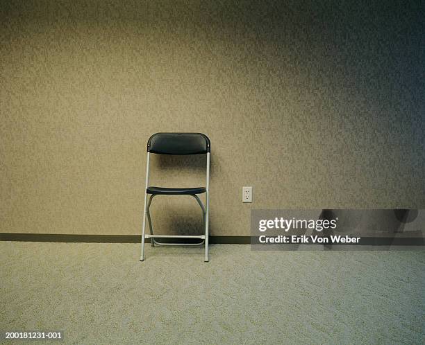 folding chair in empty room - folding chair stock-fotos und bilder