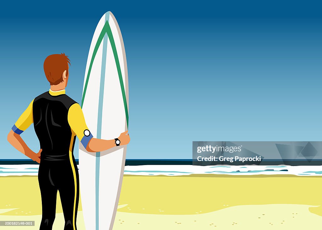 Man holding surfboard, standing on beach, rear view