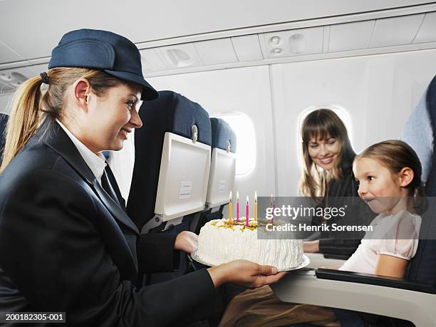 air stewardess presenting birthday cake to seated girl (5-7) - airplane food stock pictures, royalty-free photos & images