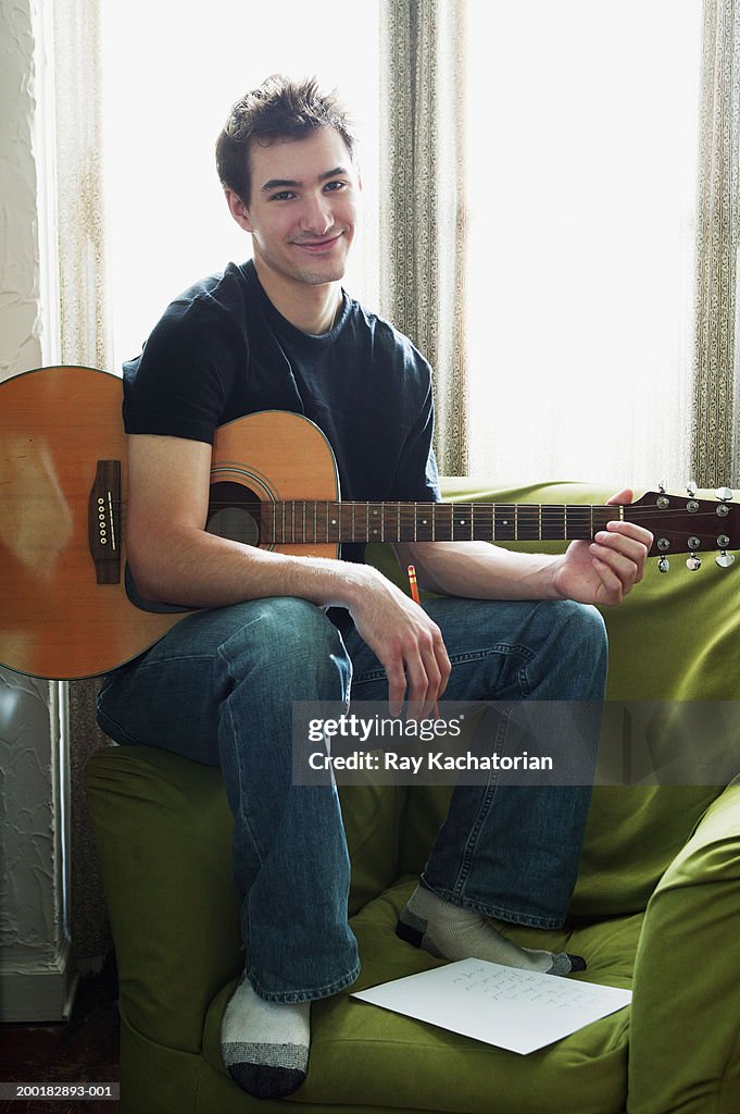 Young man playing guitar, portrait