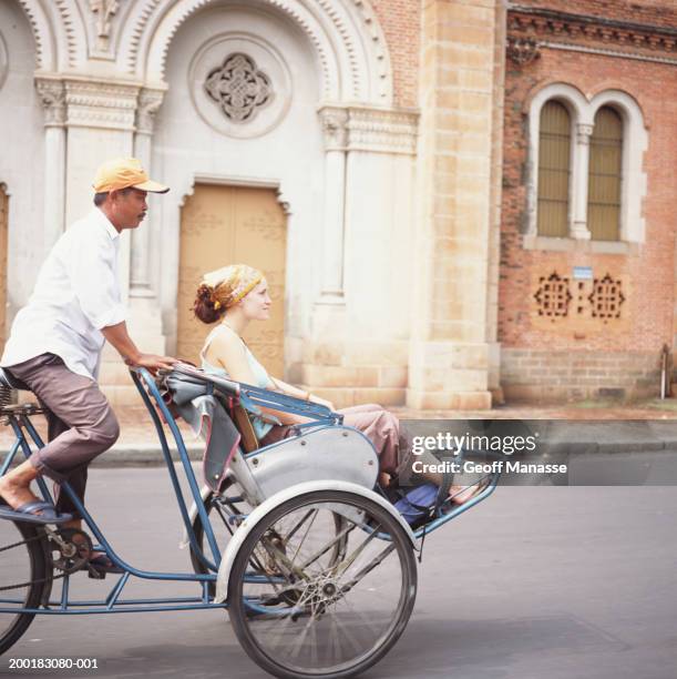 vietnam, ho chi minh city, young woman riding on pedicab, side view - pedicab stock pictures, royalty-free photos & images