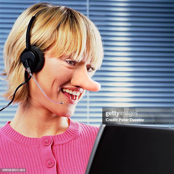 young woman with long nose wearing headset, smiling - pinocchio - fotografias e filmes do acervo