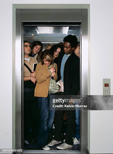 group of people crammed into lift - beengt stock-fotos und bilder