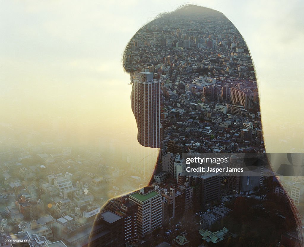 Cityscape and young woman, rear view (double exposure)