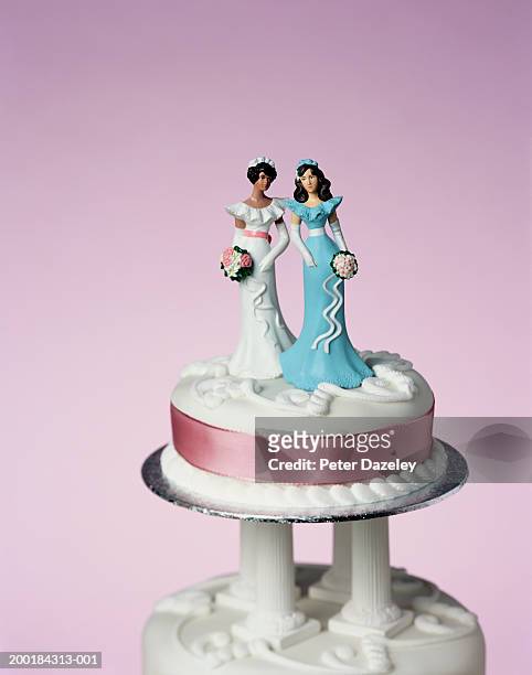 top tier of wedding cake decorated with two model brides, close-up - wedding cakes stock pictures, royalty-free photos & images