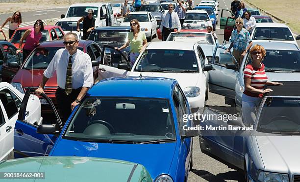 group of people standing by cars in traffic jam - traffic jam stock pictures, royalty-free photos & images