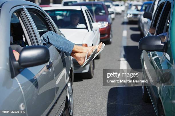 mature man hanging feet outside of car window in traffic jam - sandal stock pictures, royalty-free photos & images