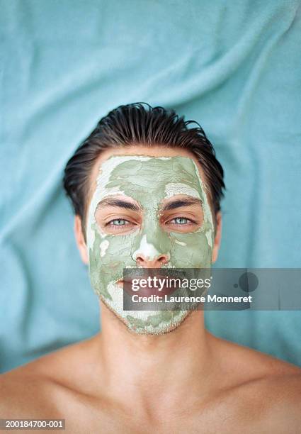 young man wearing mud mask, close-up, portrait - men facial stock pictures, royalty-free photos & images