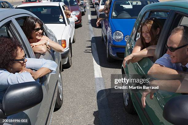 people leaning out windows of cars in traffic jam - cars traffic jam fotografías e imágenes de stock