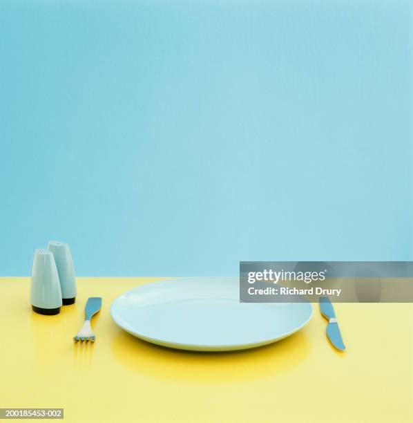 plate, utensils and salt and pepper shakers on table - blue plate stock pictures, royalty-free photos & images