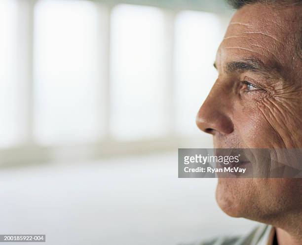 mature man smiling, side view - hispanic man profile hopeful stock-fotos und bilder