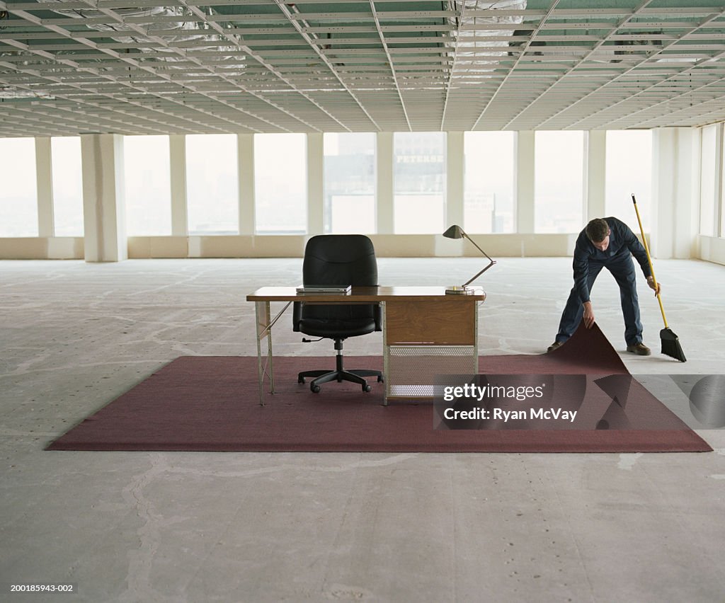 Dust Under Rug Janitor Sweeping Dust Under Rug In Office Space High-Res Stock Photo ...
