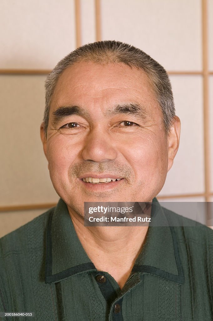 Mature man smiling, indoors, portrait