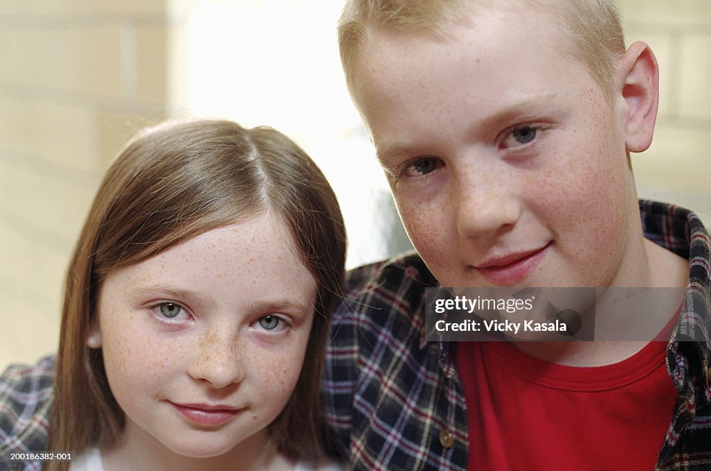 Girl and boy (9-11)standing together, smiling, portrait