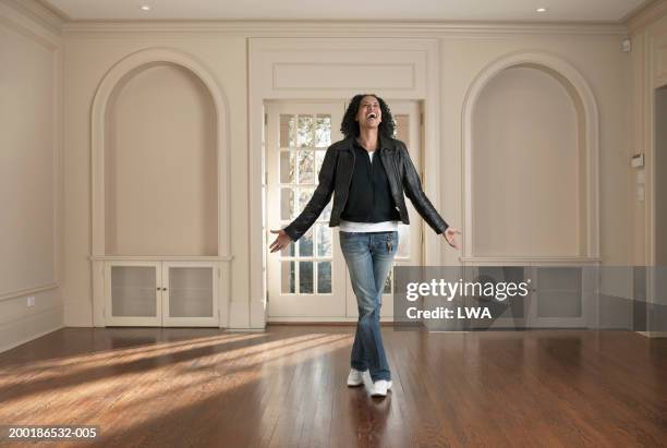 woman standing in barren room, arms outstretched, smiling - women wearing nothing fotografías e imágenes de stock