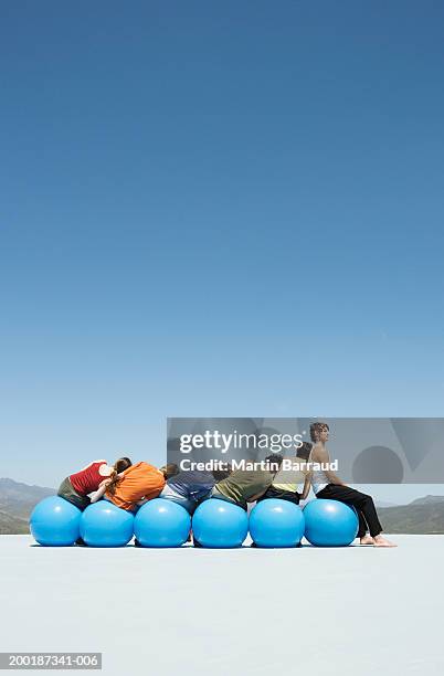 group of people on inflatable hoppers, leaning on each other, outdoors - hoppity horse 個照片及圖片��檔