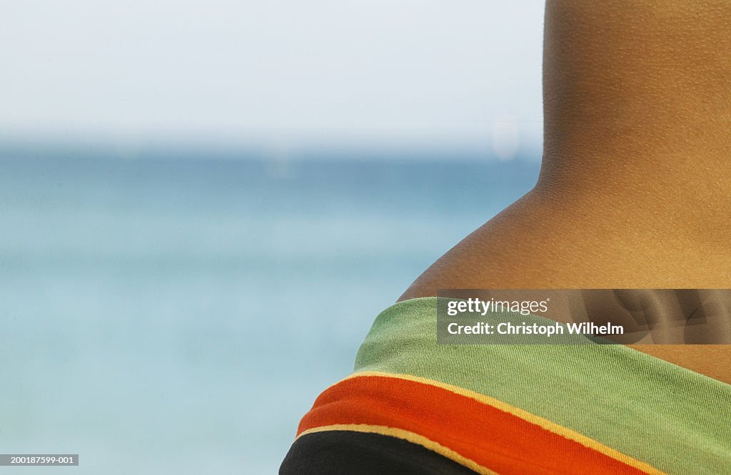 Woman on beach wearing sarong, mid section, close-up