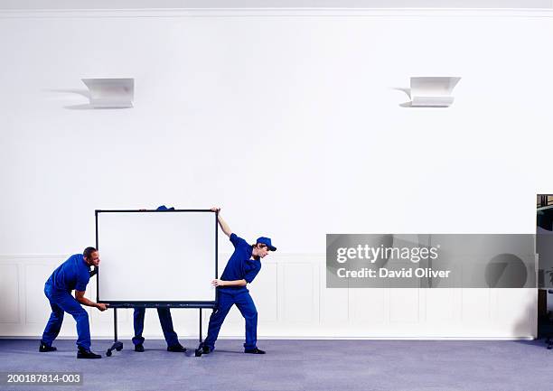 three men in corridor moving screen - moving service imagens e fotografias de stock