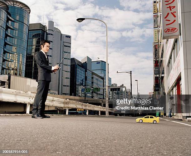 businessmen operating remote controlled toy car, side view - remote controlled car stockfoto's en -beelden