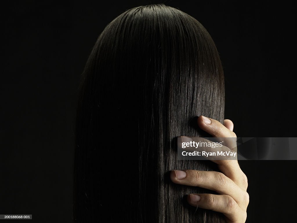 Young man touching young woman's hair, rear view, close-up