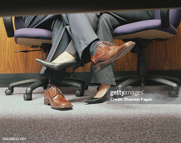 business couple crossing legs under table, low section - footsie under table stock pictures, royalty-free photos & images