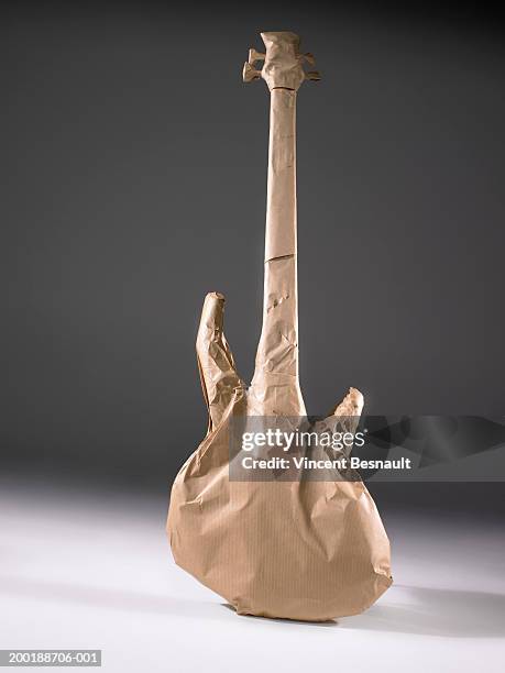 electric guitar wrapped in brown paper - wrapping paper stock-fotos und bilder