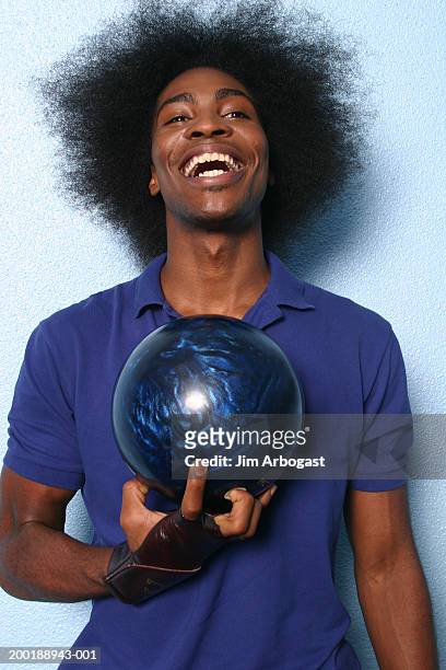 young man laughing, holding bowling ball - man holding bowling ball stock pictures, royalty-free photos & images