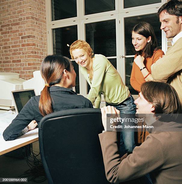 group of work colleagues gathered around laptop computer, smiling - business mann laptop stock pictures, royalty-free photos & images