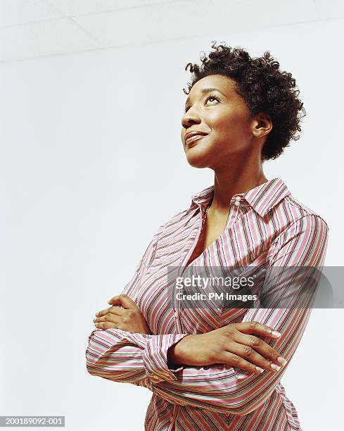 businesswoman with arms folded looking upward, smiling - looking up stock pictures, royalty-free photos & images