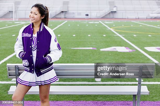 female cheerleader (16-18) standing near football field, portrait - teen cheerleader - fotografias e filmes do acervo