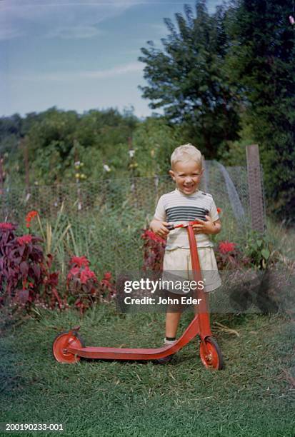 boy (3-5) standing with scooter in garden, portrait - 1952 stock pictures, royalty-free photos & images