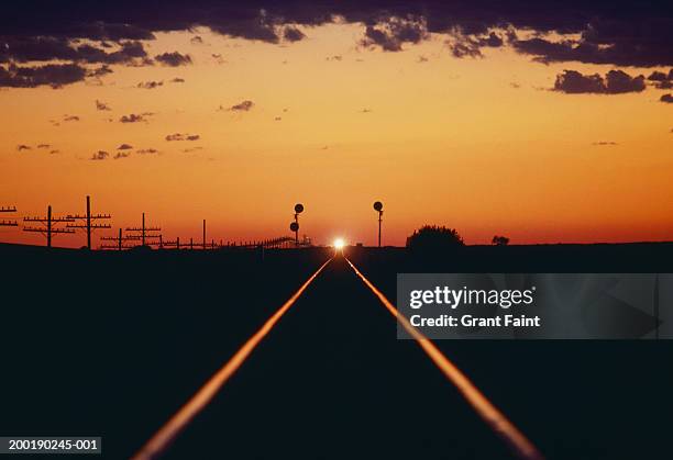 train on tracks at horizon, sunset - montana western usa stock-fotos und bilder