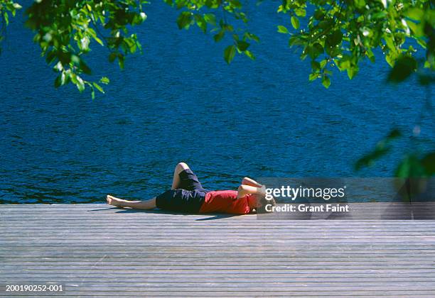 boy (11-13) lying on dock, looking at sky, side view, summer - terrace british columbia stock pictures, royalty-free photos & images