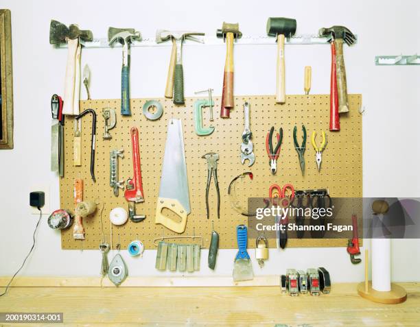 various tools hanging on grid above workbench - workbench stock pictures, royalty-free photos & images