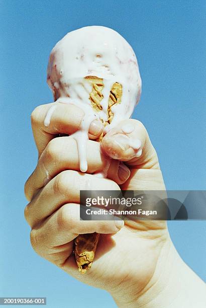 woman holding melting ice cream cone, close-up - ice cream cone stockfoto's en -beelden