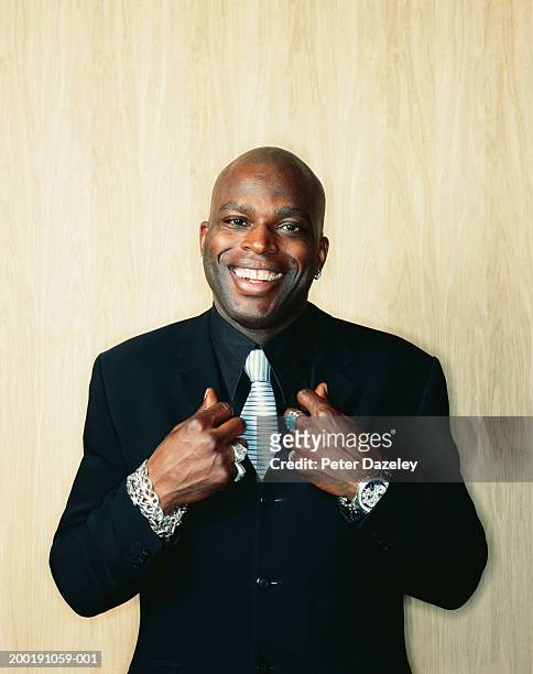 businessman wearing lots of jewellery, tugging lapels, portrait - black lapel stock pictures, royalty-free photos & images