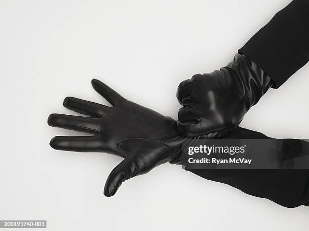 mature woman adjusting leather gloves, close-up of hands - gants de sport photos et images de collection