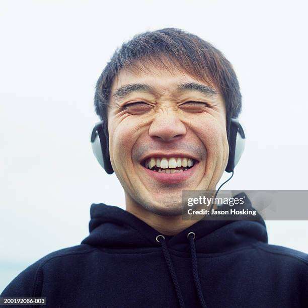 man wearing headphones, laughing - hoodie headphones stock pictures, royalty-free photos & images