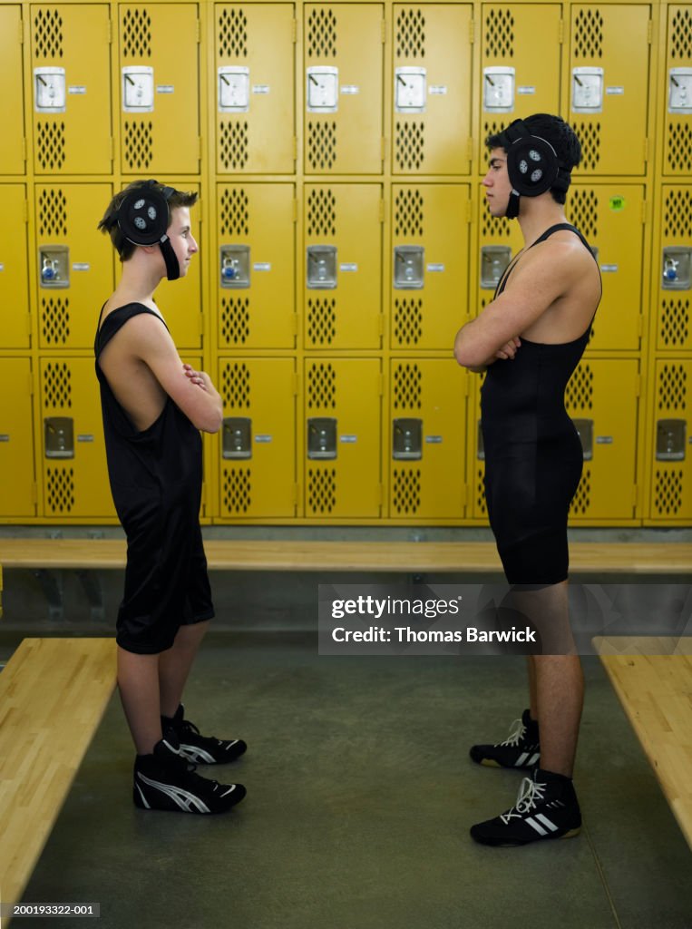 Teenage (13-18) wrestlers facing off in locker room, side view