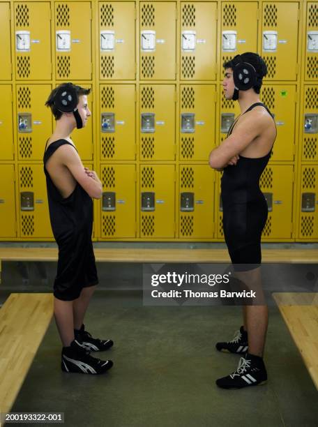 teenage (13-18) wrestlers facing off in locker room, side view - boys wrestling stock pictures, royalty-free photos & images