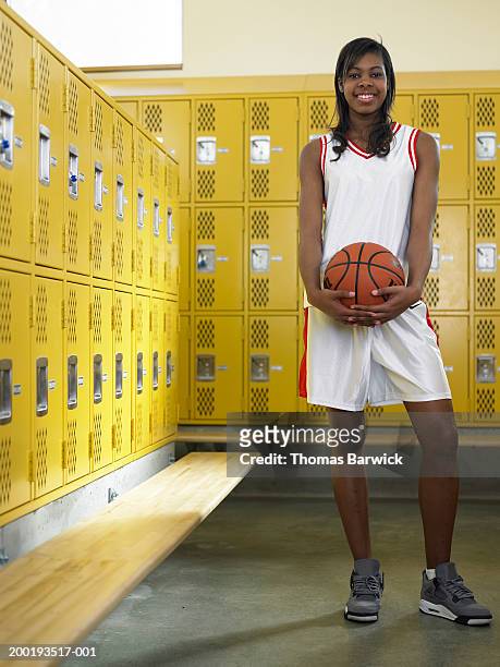 teenage girl (15-17) basketball player holding ball, portrait - teenage girl basketball photos et images de collection
