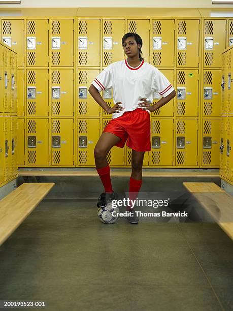 teenage girl (15-17) standing with soccer ball in locker room - high school locker room stock pictures, royalty-free photos & images