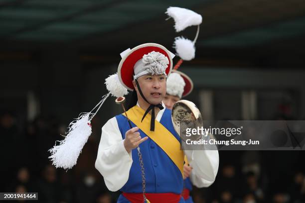 South Korean performers wearing traditional clothes participate in a traditional game for wishing good luck in Lunar New Year holiday at the National...