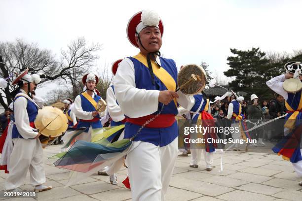 South Korean performers wearing traditional clothes participate in a traditional game for wishing good luck in Lunar New Year holiday at the National...