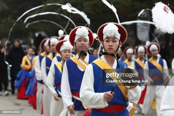 South Korean performers wearing traditional clothes participate in a traditional game for wishing good luck in Lunar New Year holiday at the National...