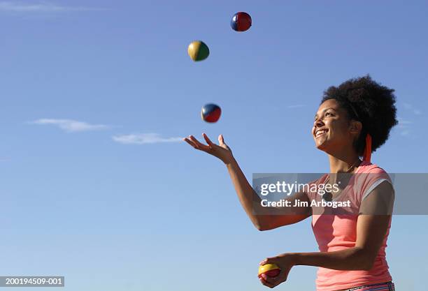 young woman juggling, side view (blurred motion) - juggling stock pictures, royalty-free photos & images