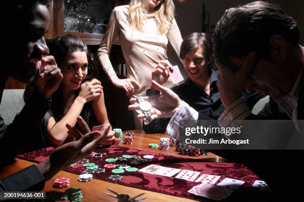 five young adults playing poker, one man betting wristwatch - poker ストックフォトと画像