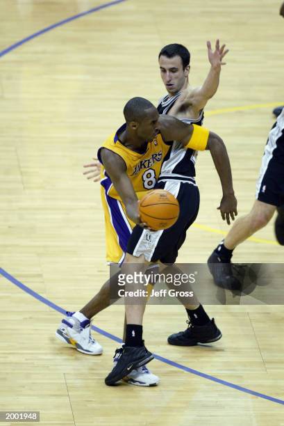 Kobe Bryant of the Los Angeles Lakers looks to pass around Emanuel Ginobili of the San Antonio Spurs in Game three of the Western Conference...