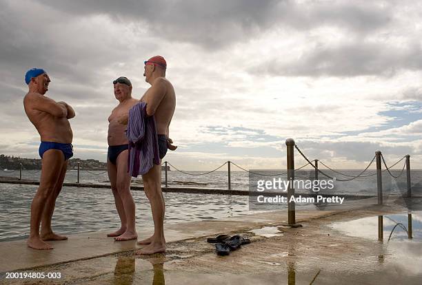 drei älteren herren an den infinity-pool, lachen - australian swimming stock-fotos und bilder