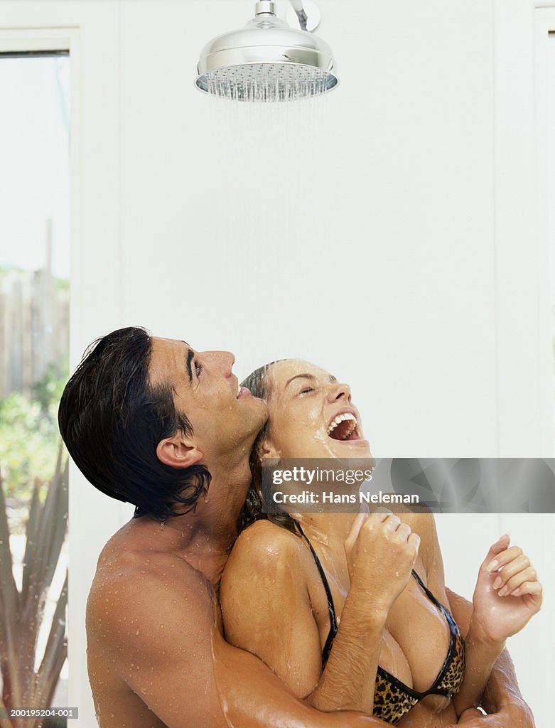 Young couple taking shower outdoors